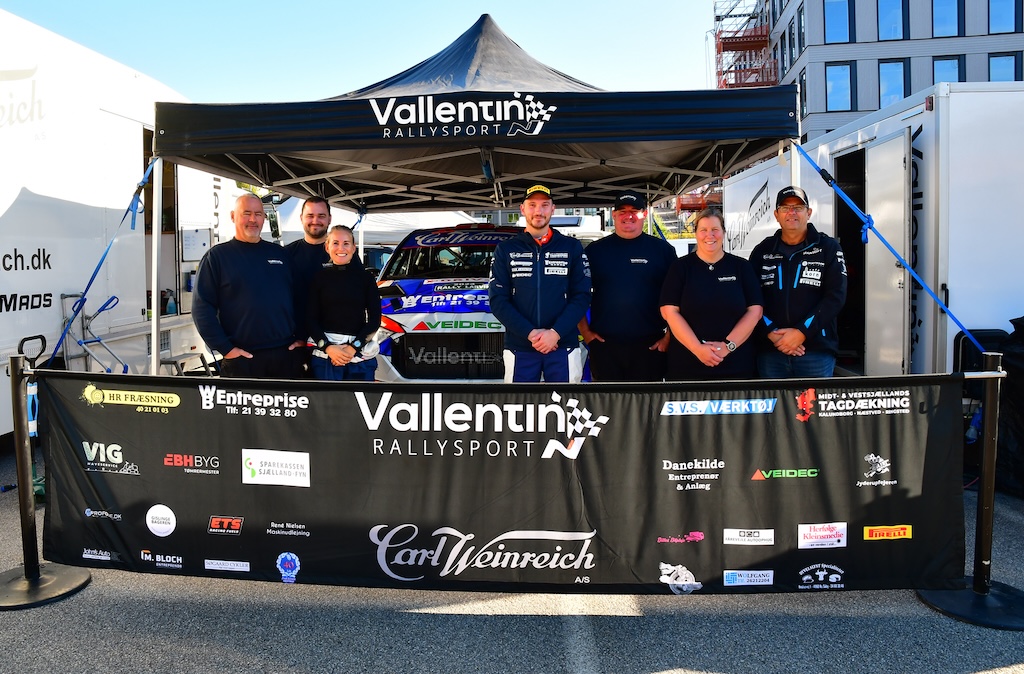 Team Vallentin Rallysport: Fra venstre Torben Vagn Hansen, Mikkel Nielsen, Line Lykke Jensen, Simon Vallentin, Bo Anders Torslunde, Lonnie Spangenberg og Henrik Andersen - og i midten teamets Hyundai i20N Rally2 fra 2023.
(Foto: Morten Dam - autoMOTIV/specialpress)